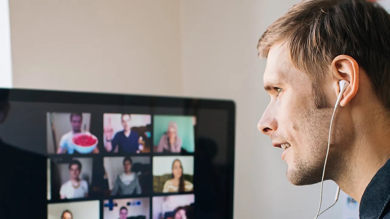 Man kijkt naar beeldscherm en zit in een online meeting.