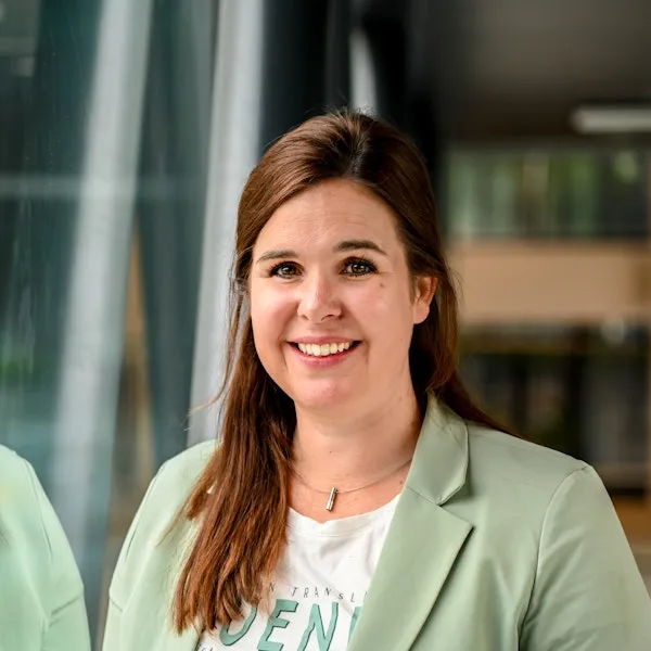 Vrouw met bruin haar in licht groen jasje