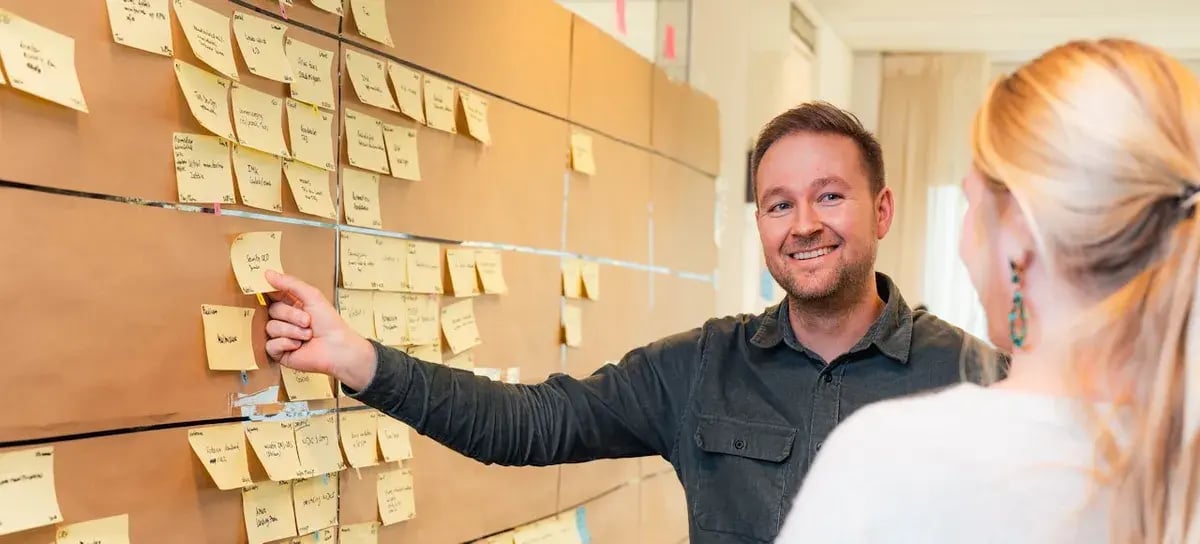 Vrouw en man voor een bord met post its