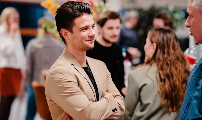 Twee mannen staan te praten bij een bijeenkomst