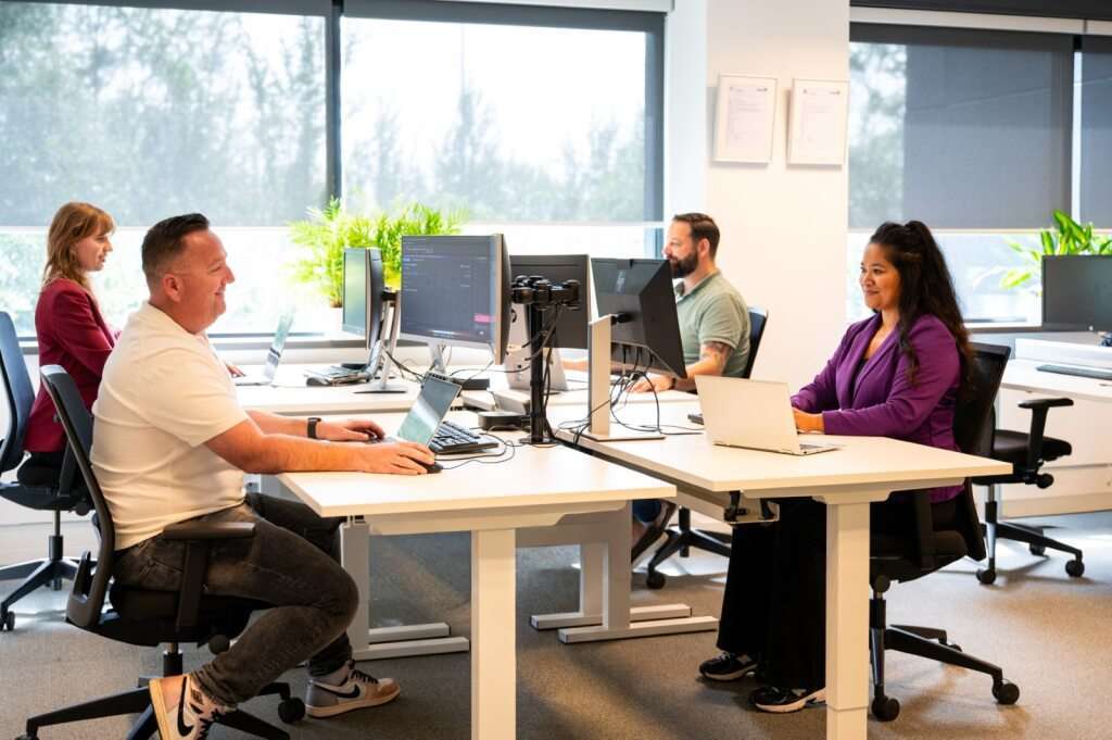 Vier collega's werken in hun kantoorblok.