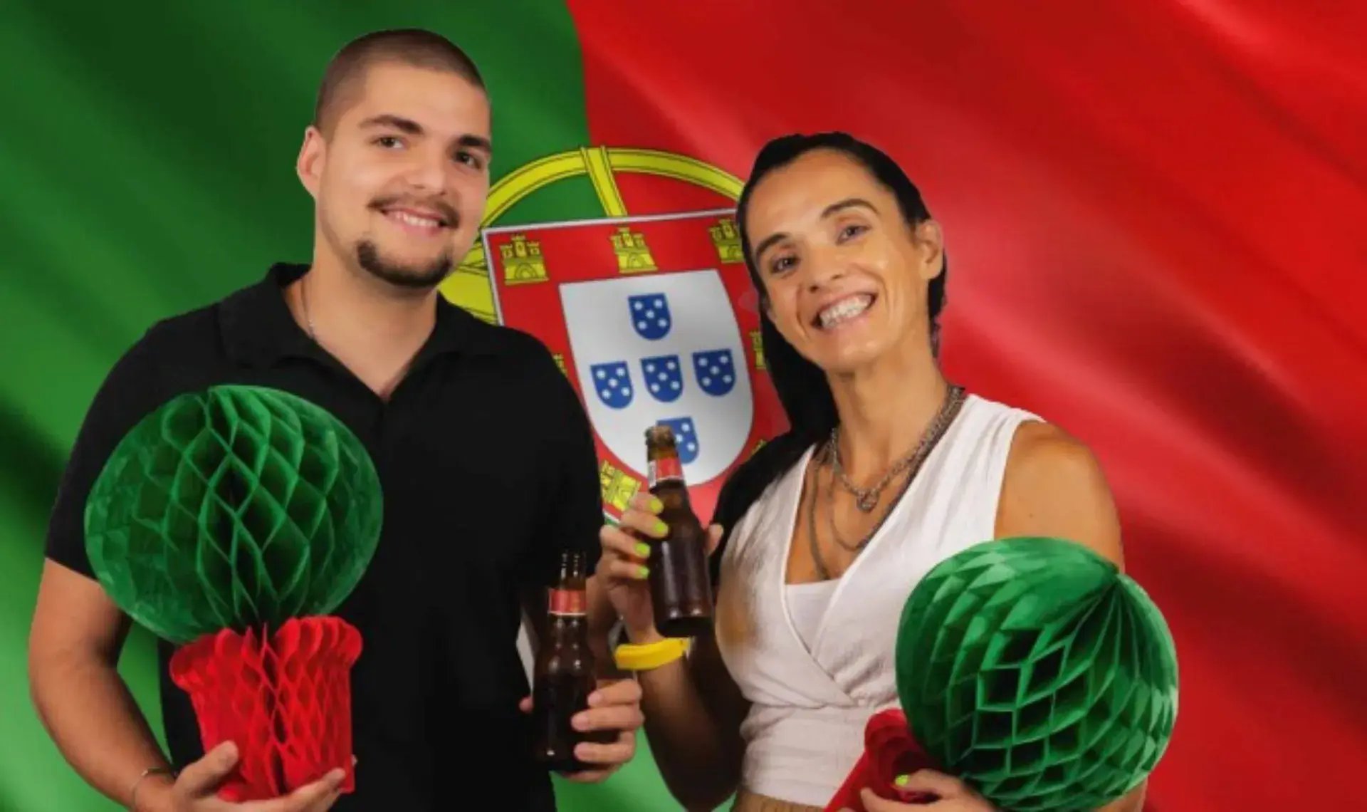 Man en vrouw staan voor Portugese vlag met biertjes in hun hand.