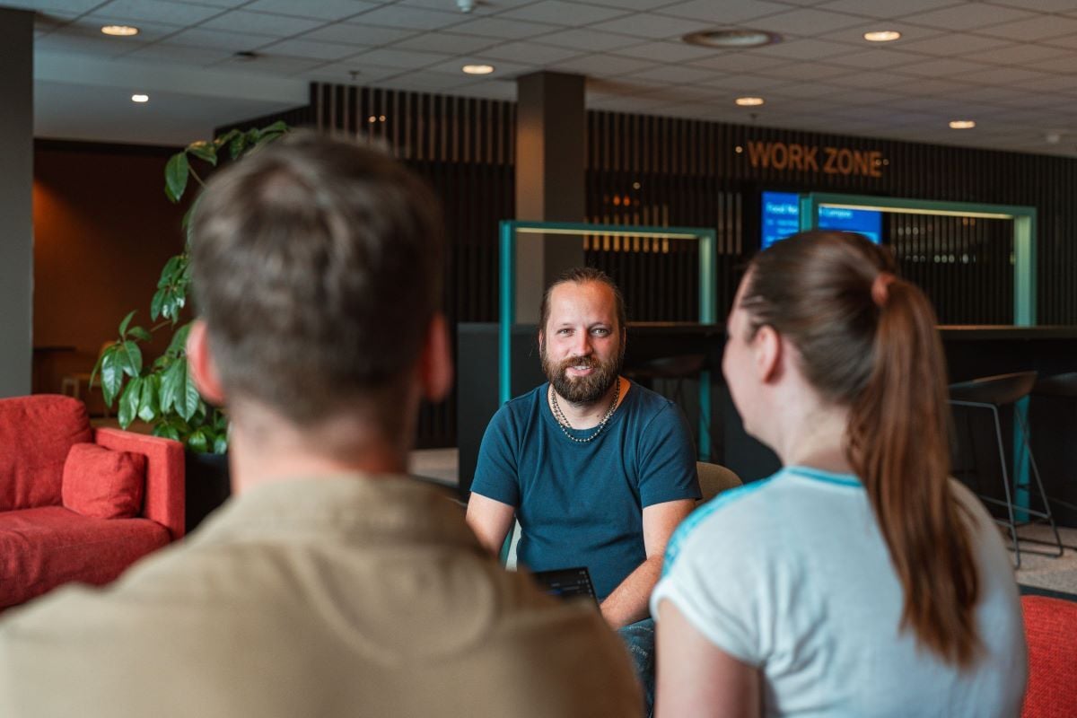 Een gesprek tussen collega's in een moderne werkruimte met de nadruk op samenwerking en interactie.