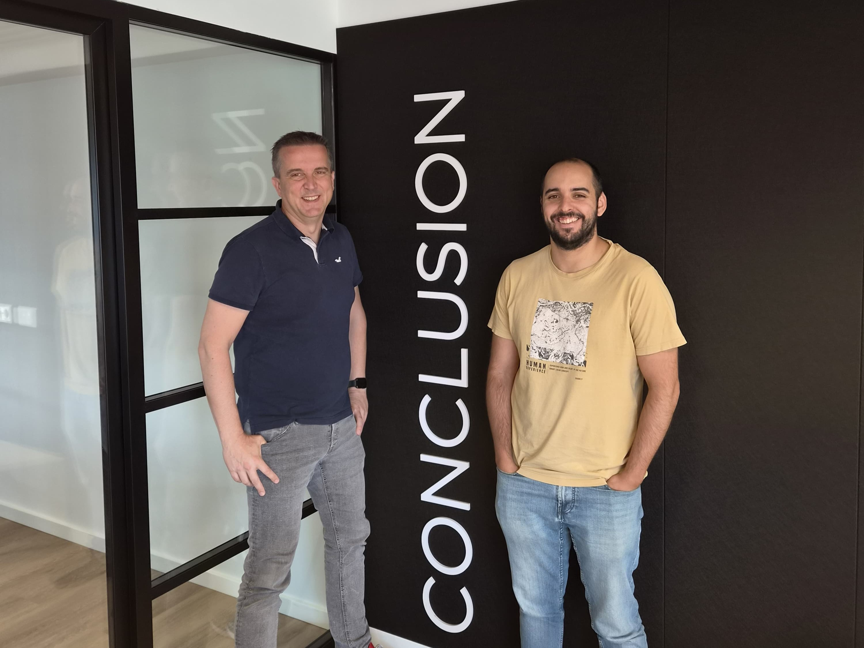 Twee mannen staan bij het Conclusion-logo