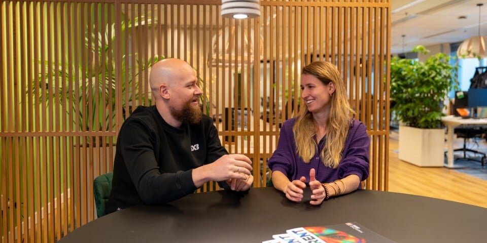 Man en vrouw in gesprek aan ronde tafel.