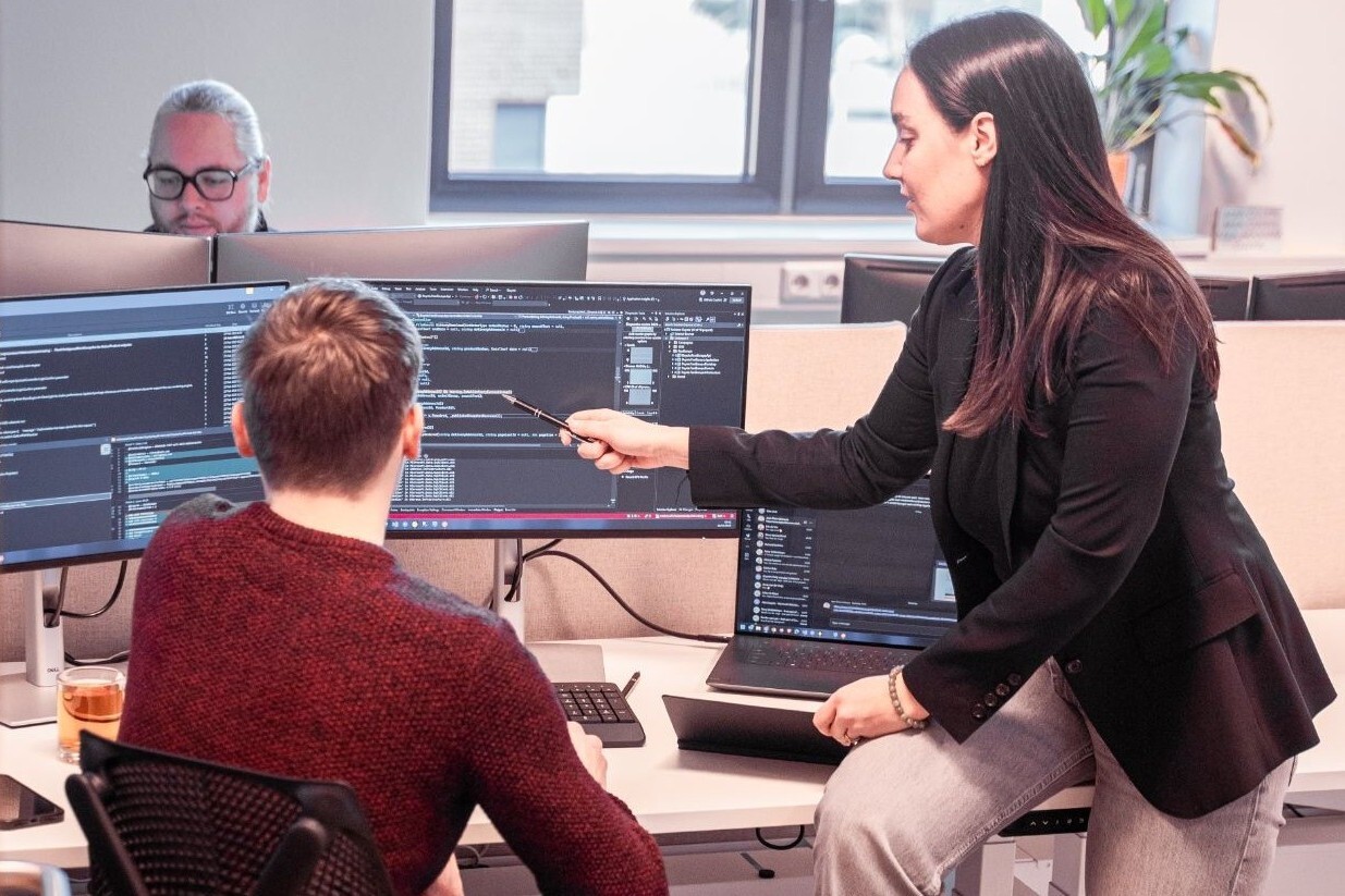 Collega's kijken samen naar computerschermen.