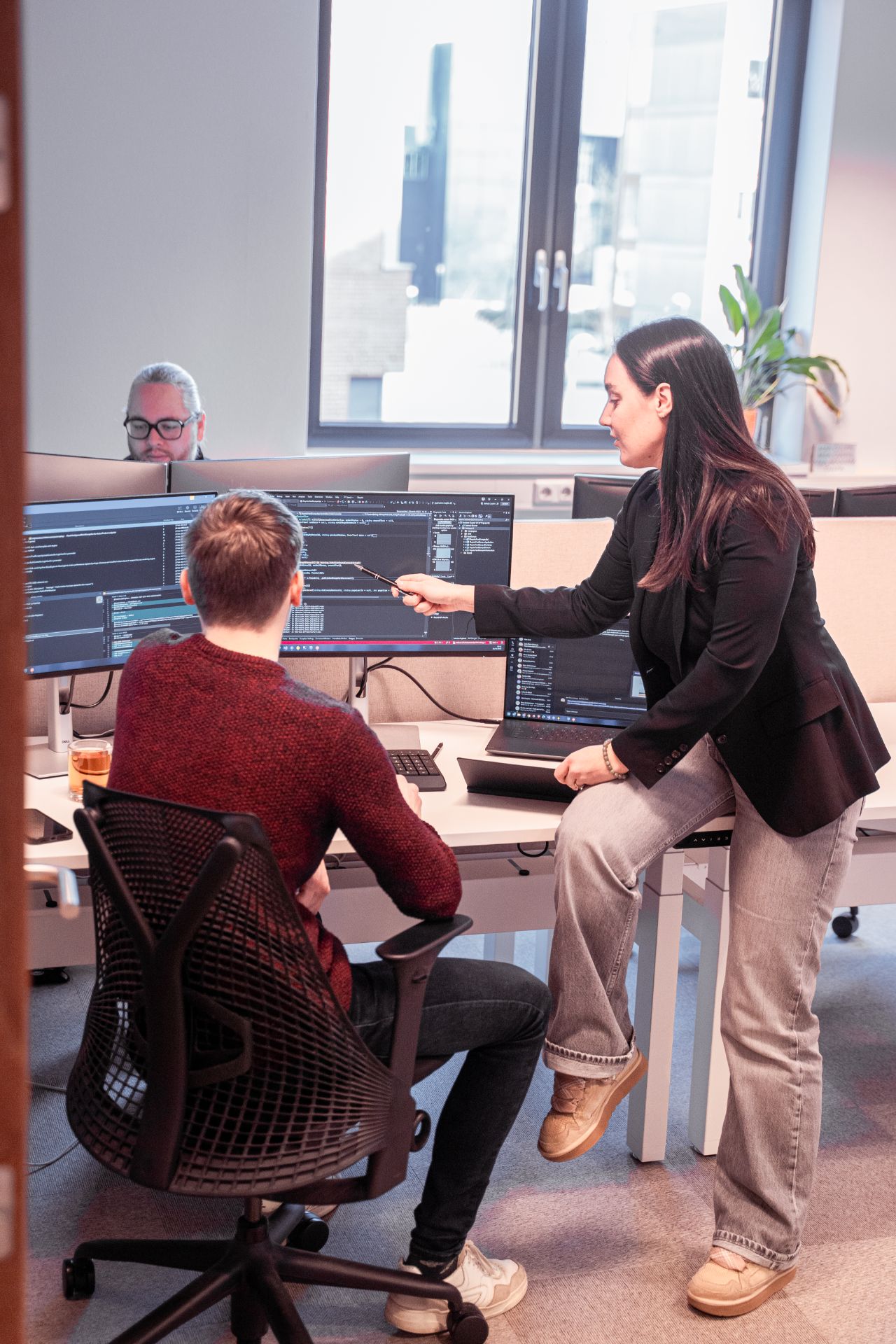 Collega's kijken samen naar computerschermen.