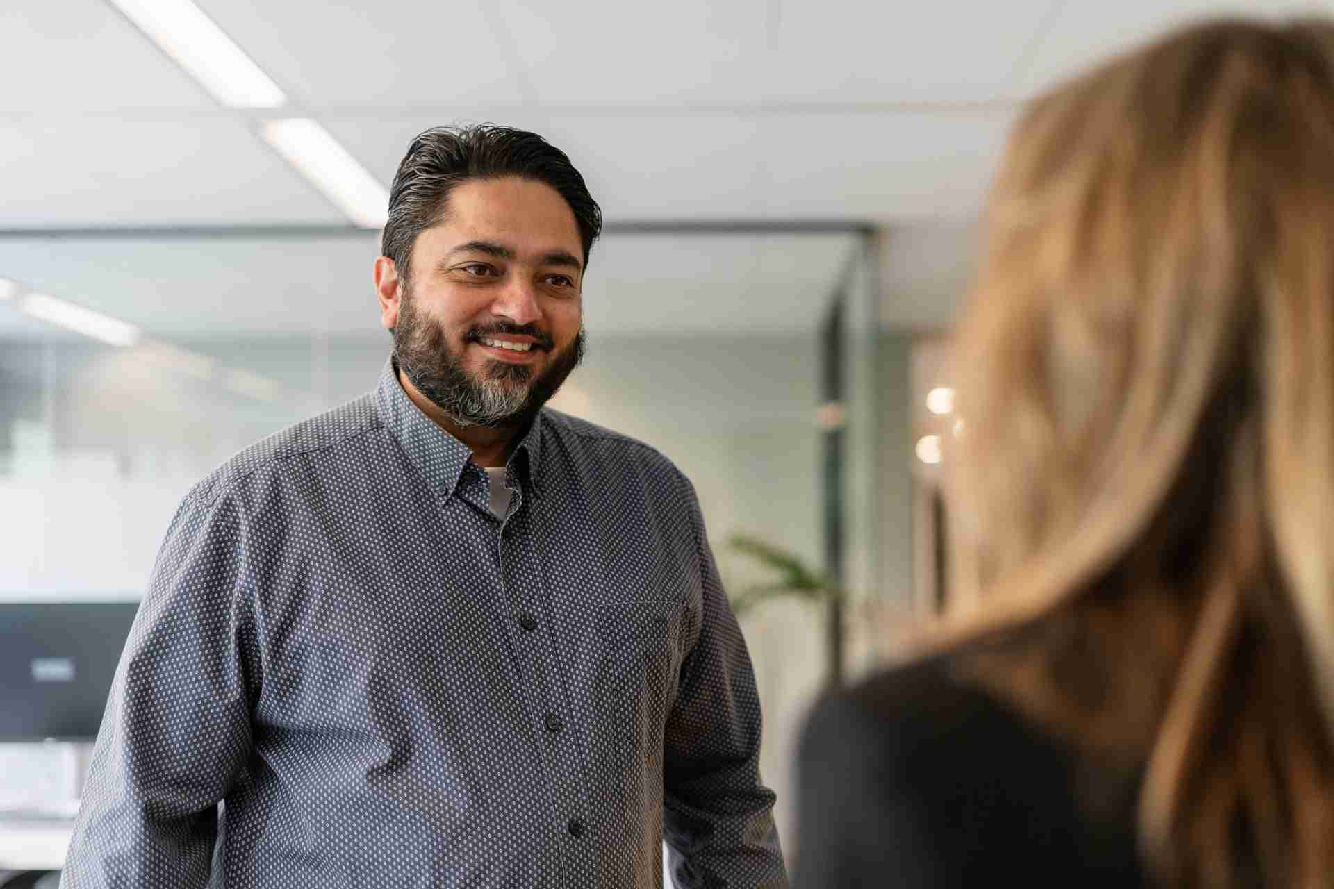 Man met baard in gesprek met vrouw.