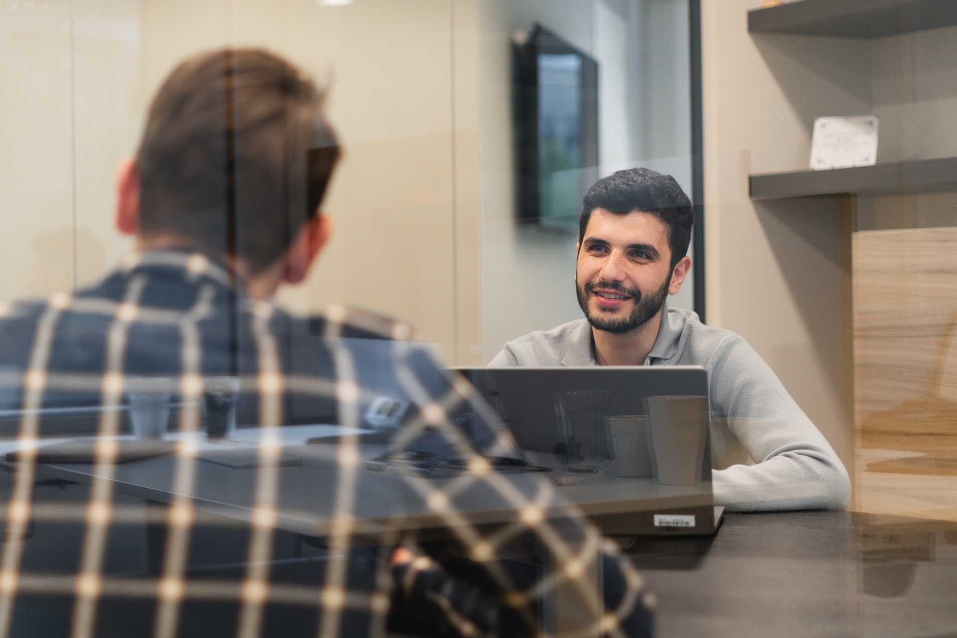 Man met baard in gesprek met andere man.