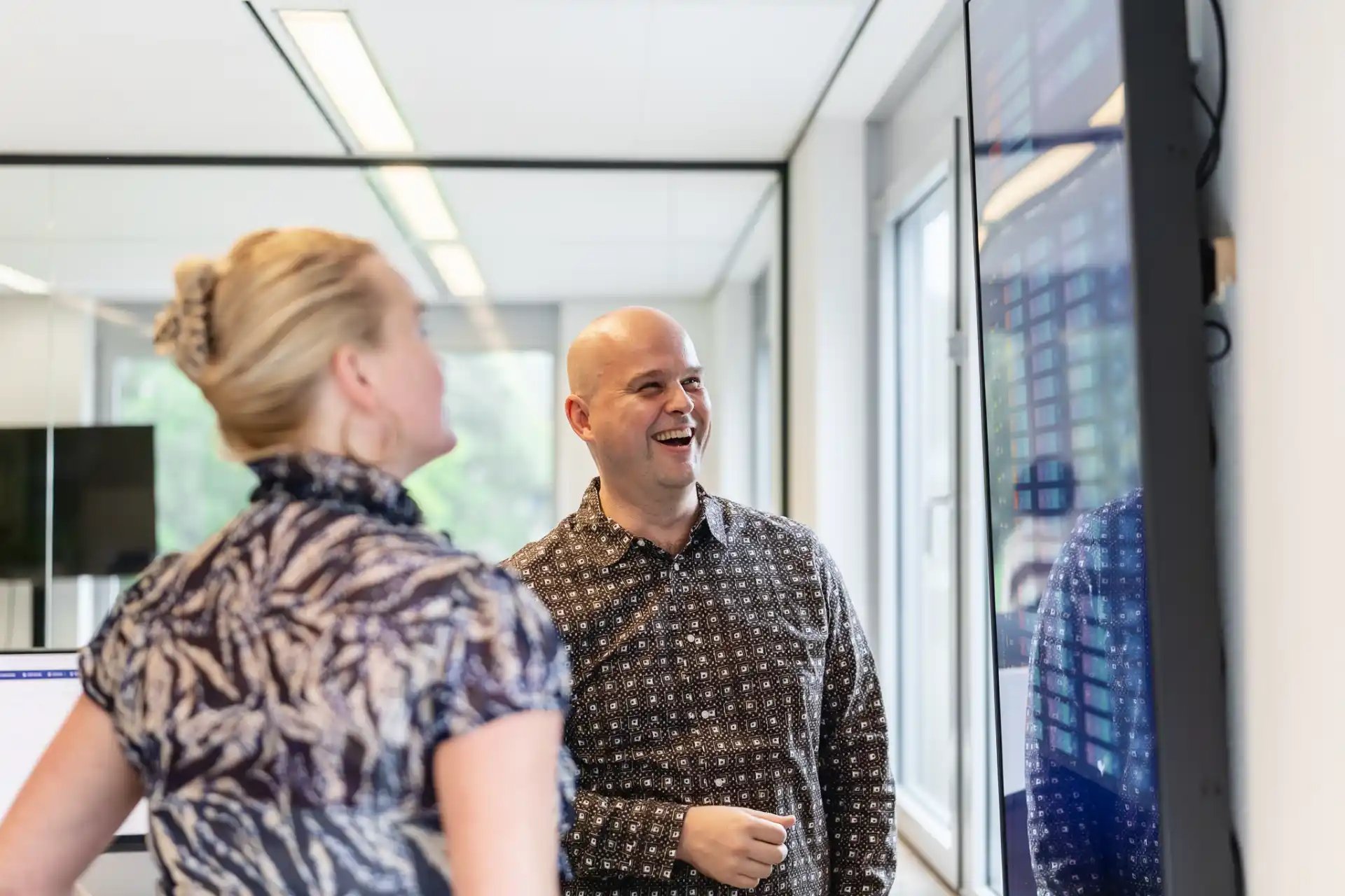 Woman and man standing in front of a screen