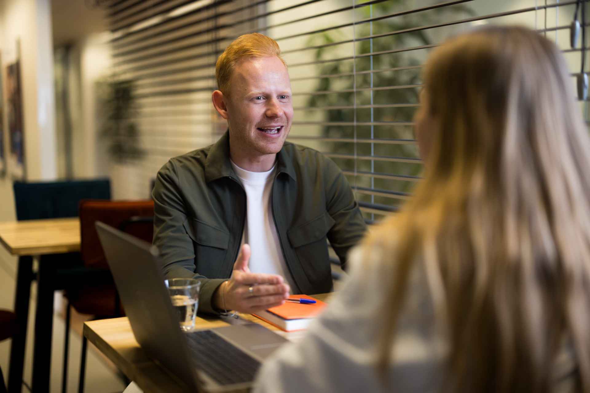 Blond man talking to a woman.