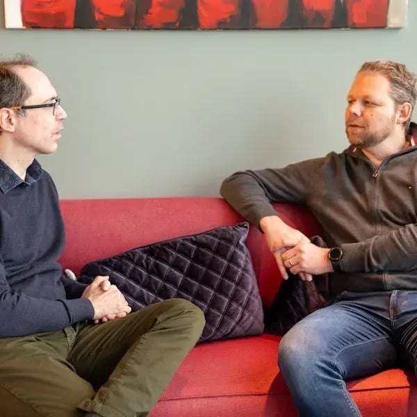 Bastiaan Sjardin en Paul de Metter op een rode bank