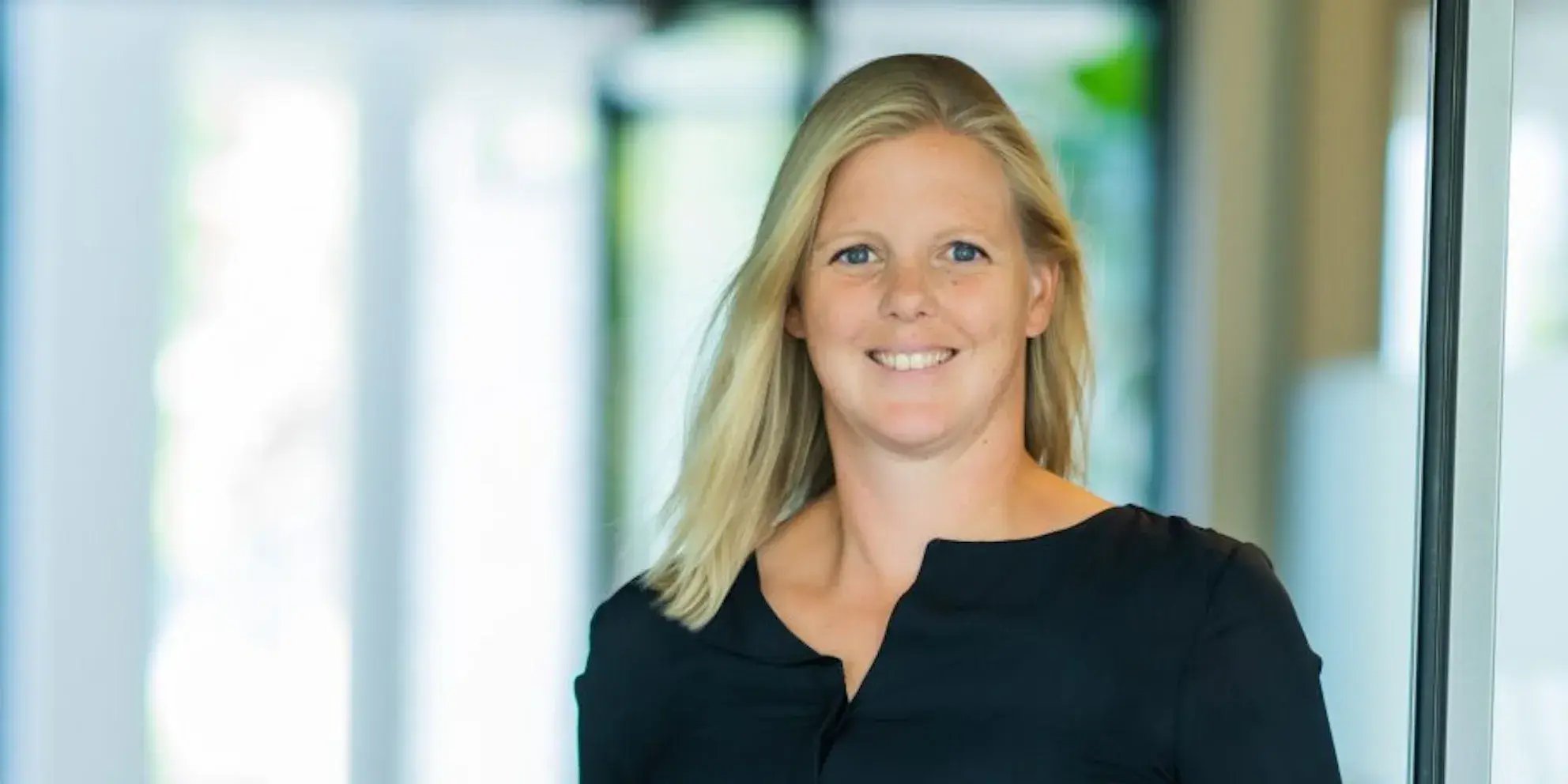 Portret van een blonde vrouw die lacht.