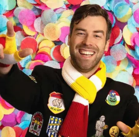 Man wearing a scarf and carnaval outfit.