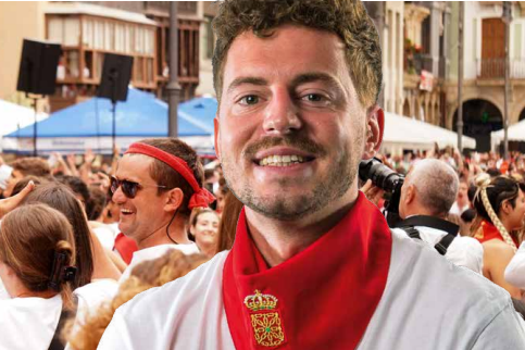 Man with red scarf looking into the camera.