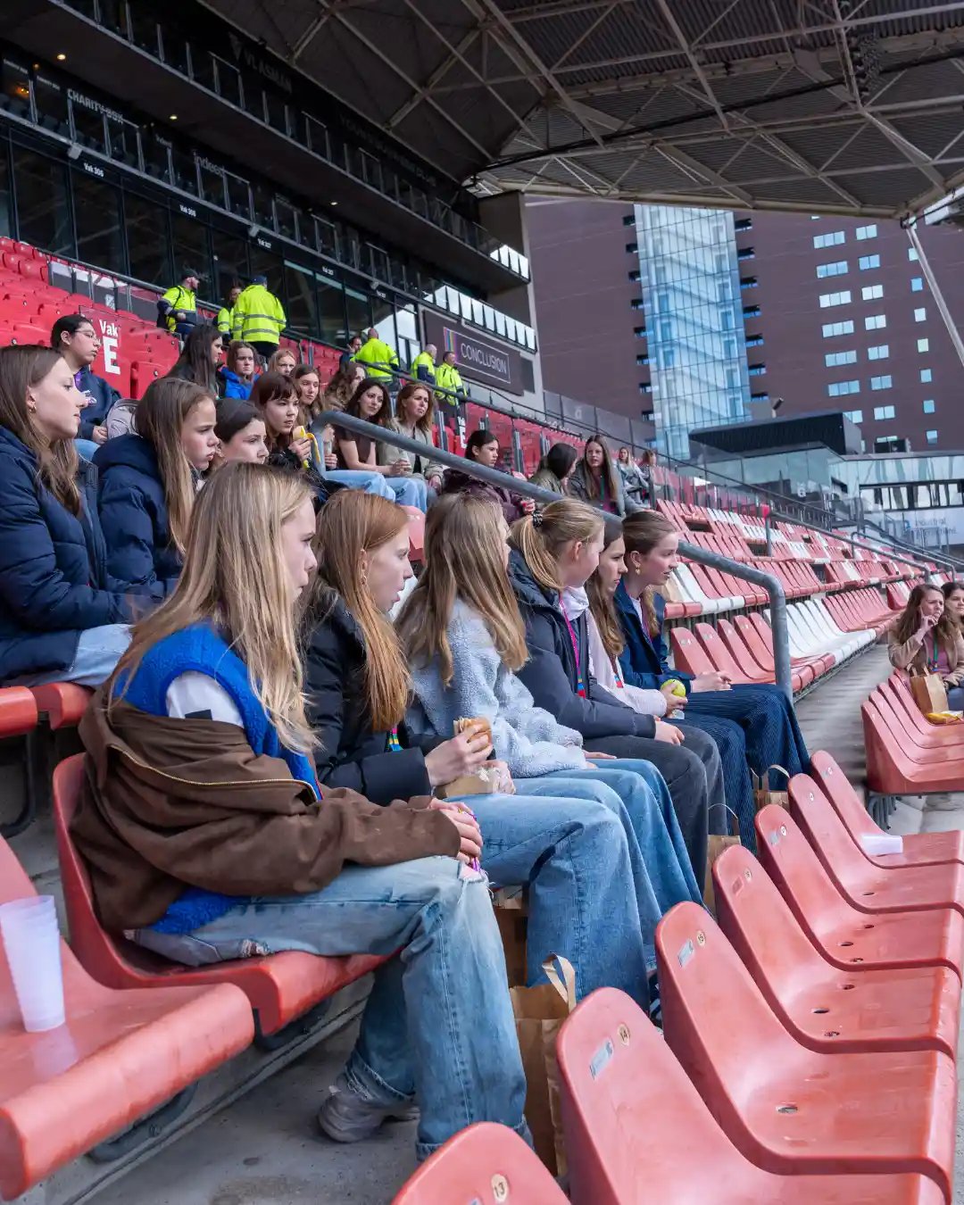 Groep meiden op voetbaltribune.