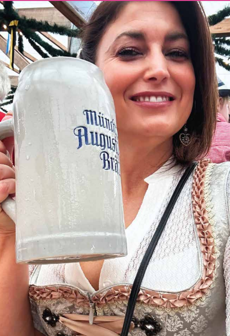 Woman with brown hair holding a beer mug.