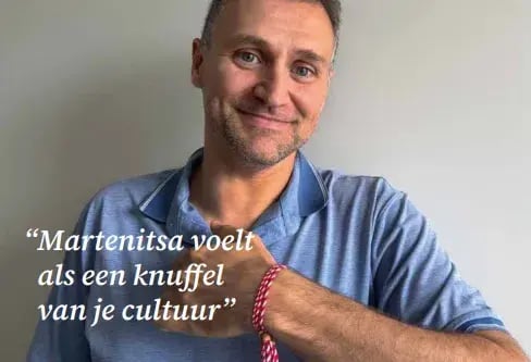 Man wearing a blue shirt and bracelet looking into the camera.