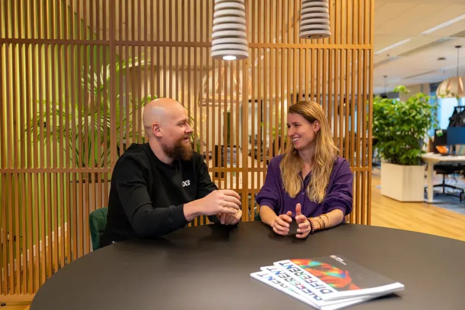 Man en vrouw samen in gesprek aan een ronde tafel.