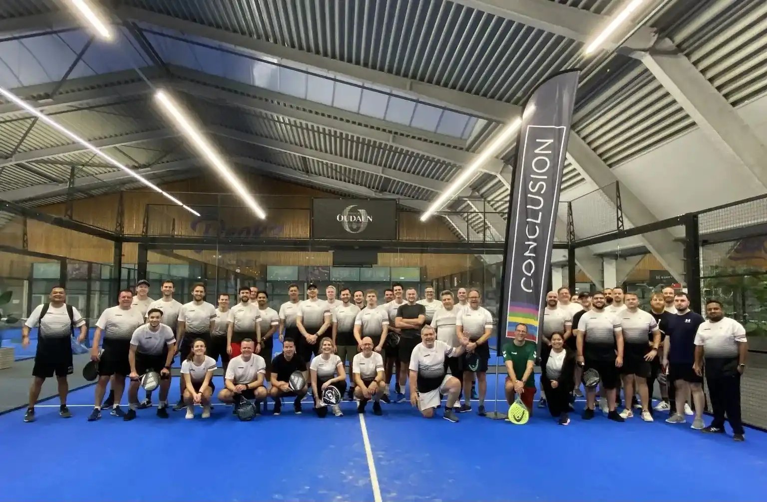 Groep mensen op de padelbaan.