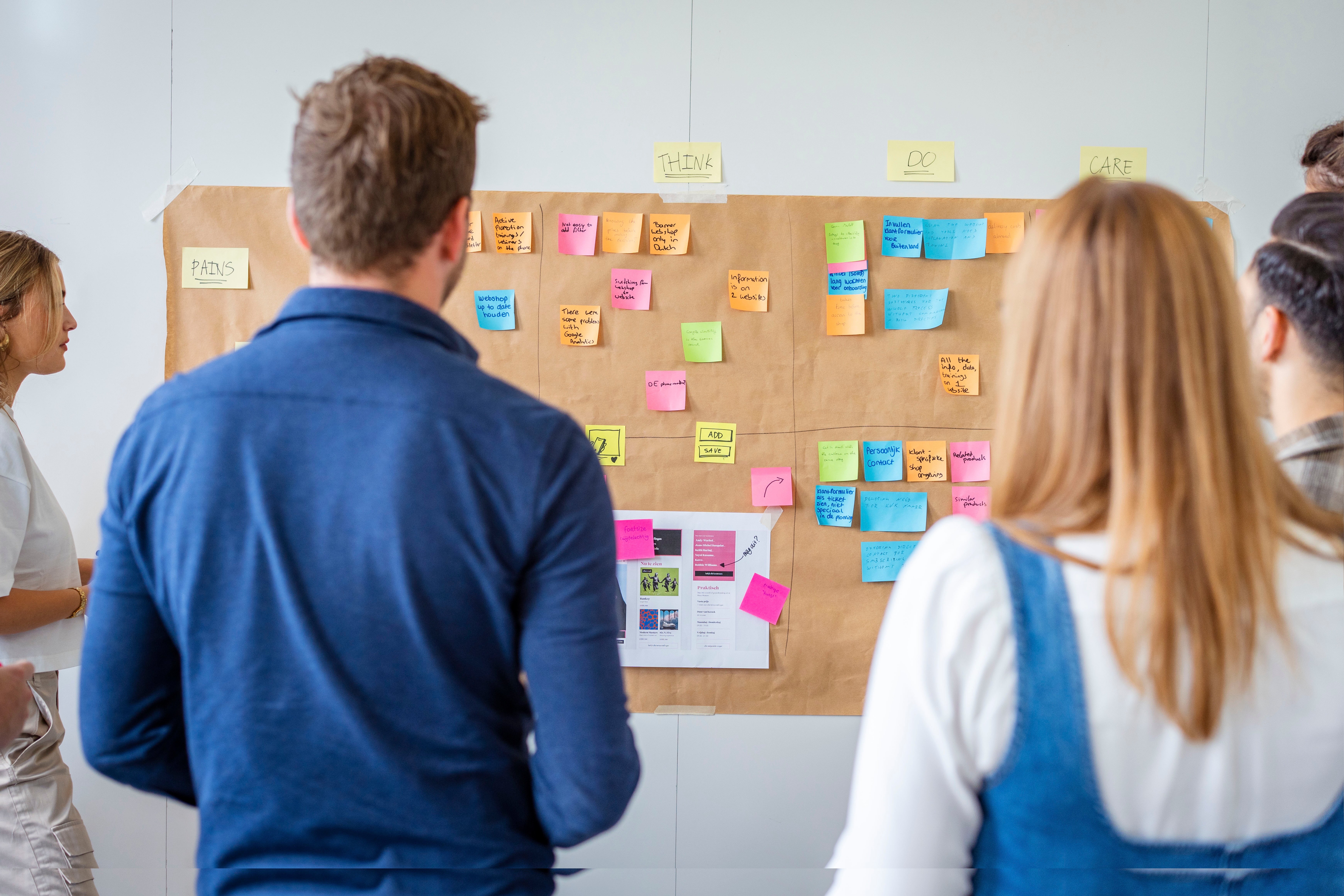 Mensen die voor een muur met post-it briefjes staan