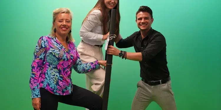 Groepsfoto met links een vrouw, in het midden een vrouw op een ladder en rechts een man die de ladder vast houdt.