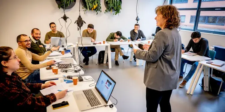 Woman giving a training to a full classroom.