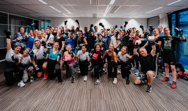 Groepsfoto van collega's in een boks les